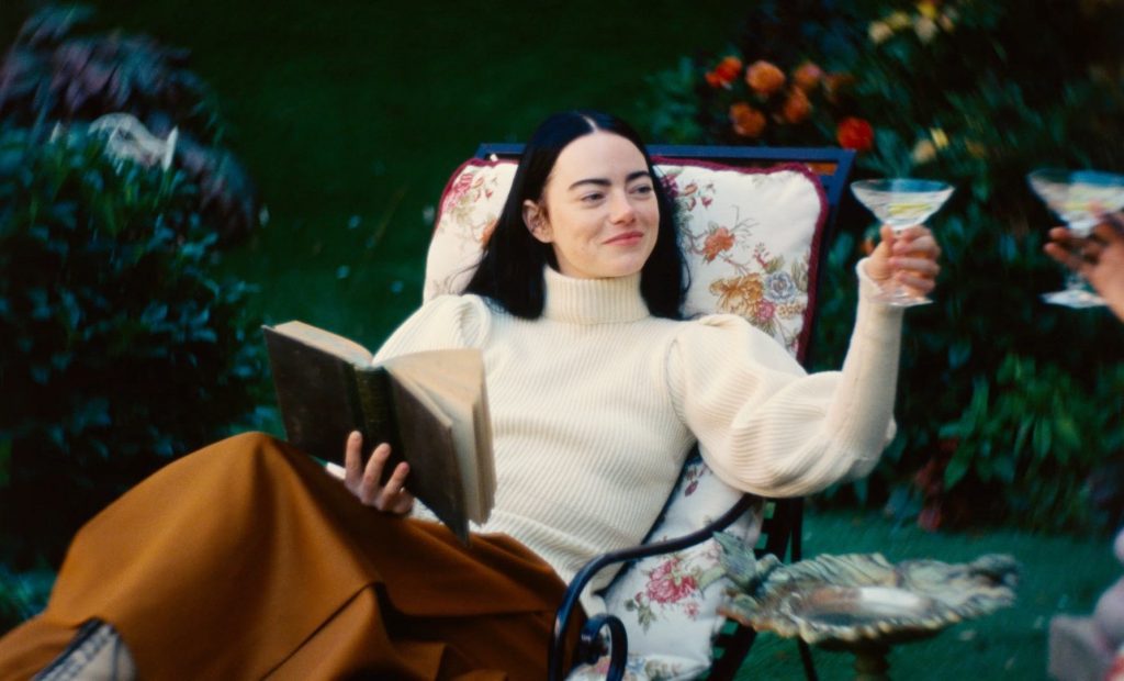 Bella (Emma Stone), confortablement installée dans le jardin du manoir de son maître, trinquant à son émancipation - Photo Courtesy of Searchlight Pictures - © 2023 Searchlight Pictures All Rights Reserved.