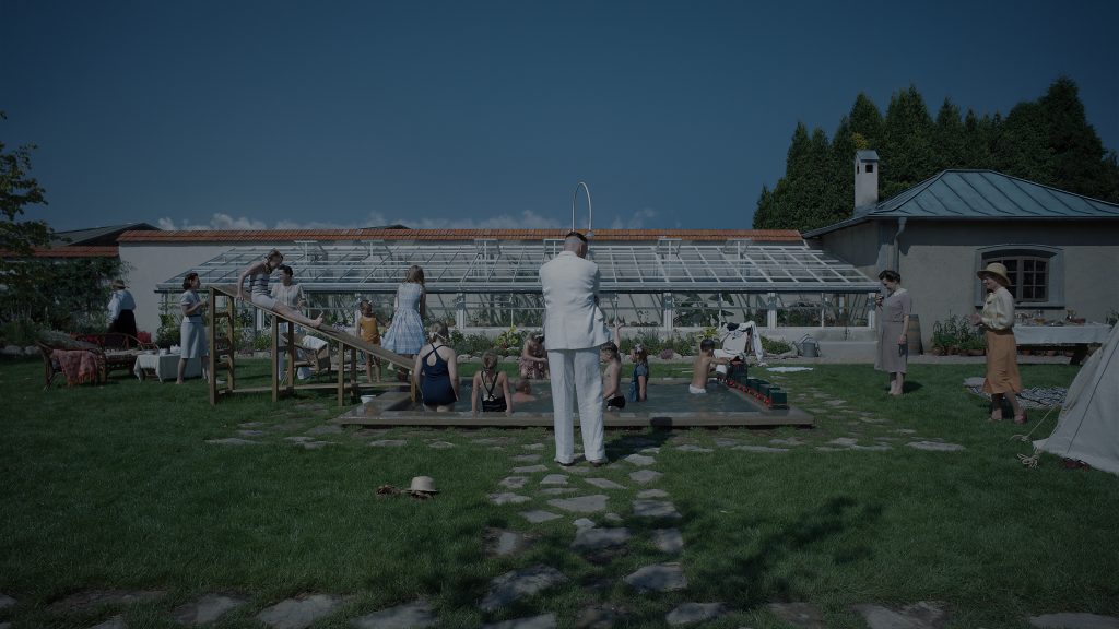 Photo représentant la famille Höss qui accueille des amis lors d'une fête. Le verdoyant jardin se transforme alors en lieu de joyeuse sauterie, à quelques mètres seulement du camp - © Bac Films / DR